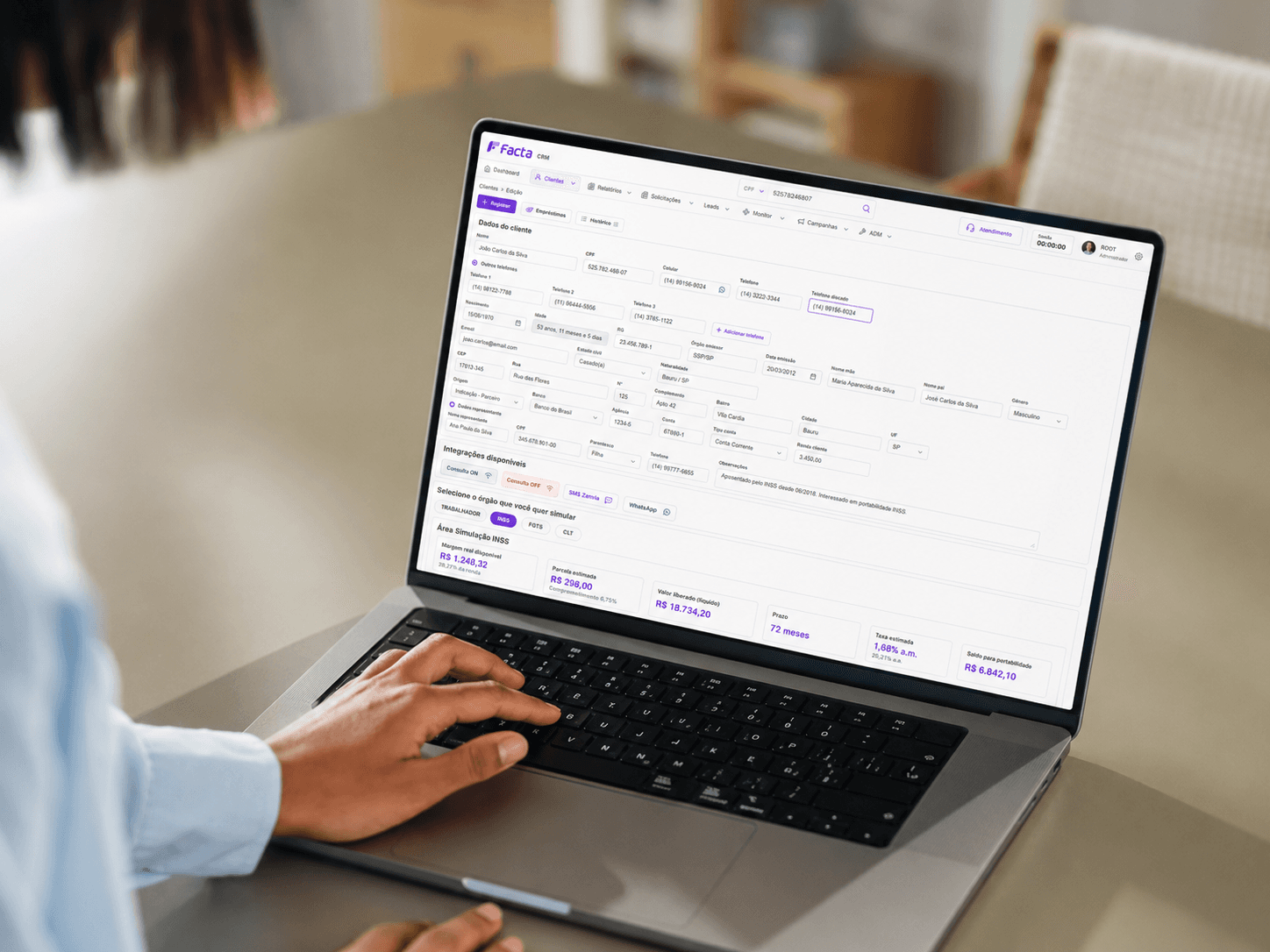 Notebook exibindo o CRM da Facta na tela de consulta de um cliente e opções de simulação